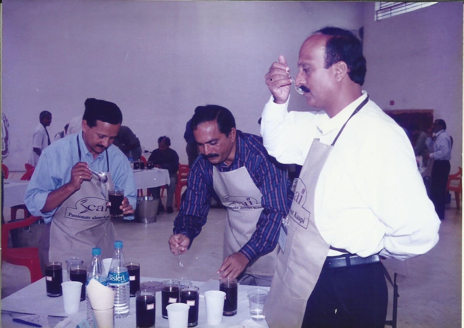 Members slurping coffee at a cupping table